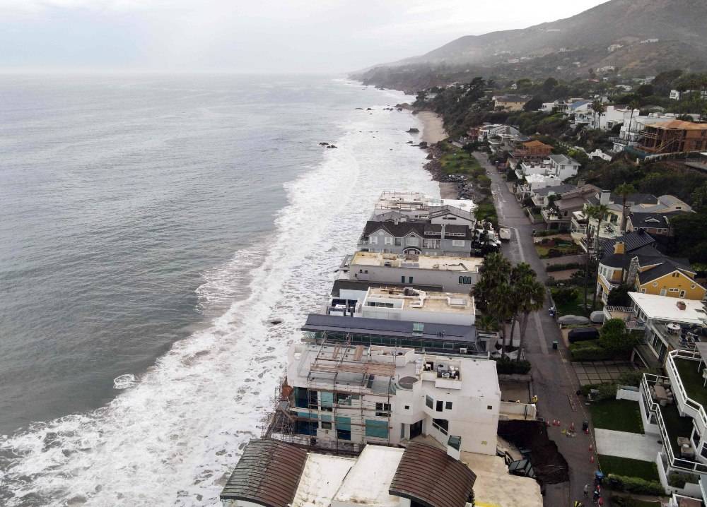 A sinkhole on a street and driveway of a seaside home affected by large swells produced by Hurricane Marie in Malibu, California. Photo by AFP