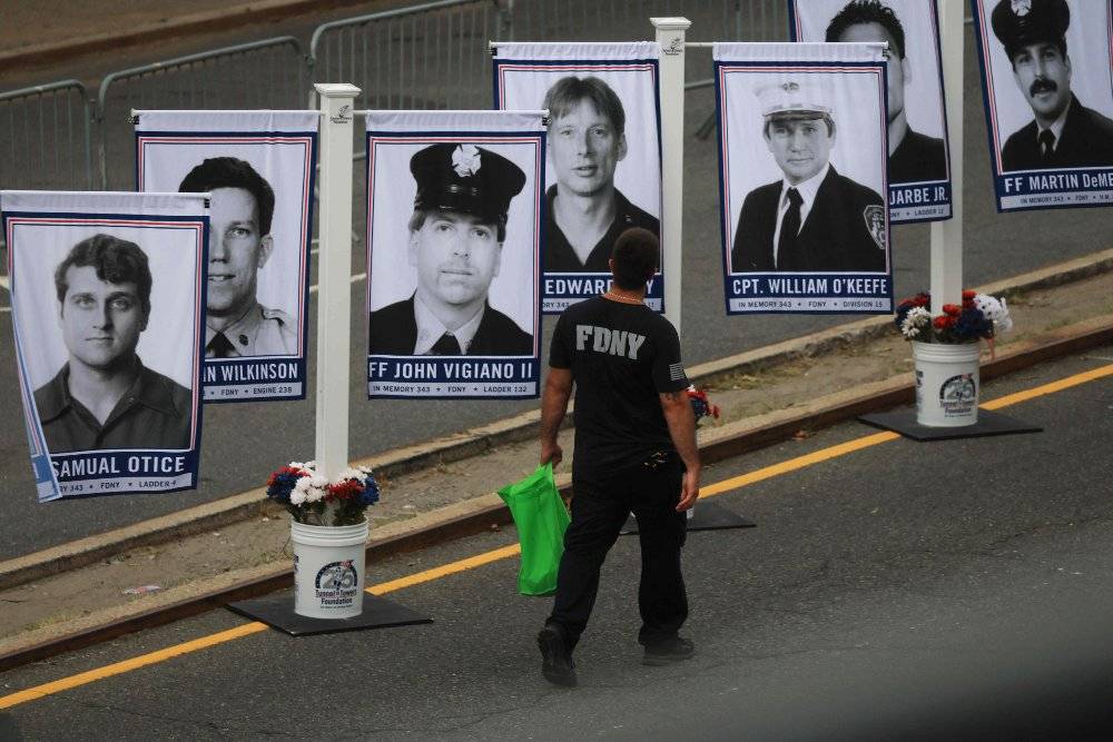 Pictures of members of the Fire Department of the City of New York (FDNY) who were killed in the attacks on Sept 11, 2001, are displayed outside of an arena during a ceremony to commemorate the 25th anniversary of the attacks. Photo by Spencer Platt/Getty Images/AFP
