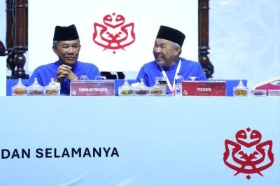 On stage, Mohamad Hasan and Ahmad Zahid Hamidi shares a moment. Photo by Halim Wahid