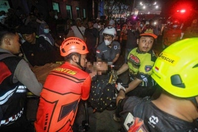Rescue teams evacuate a victim of the Virgo Transport 8 passenger ferry, which capsized while carrying 243 people on its route to Banjarmasin from Surabaya, at a hospital in Banjarmasin, South Kalimantan. Photo by AFP