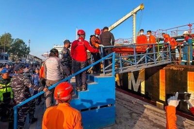 Rescue personnel stretcher out a body bag containing a deceased victim of the Virgo Transport 8 passenger ferry, which capsized Sep 13. AFP FILE PIX