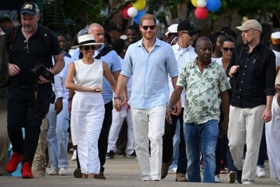Britain's Prince Harry (C), Duke of Sussex, and his wife Meghan Markle (2nd L) arrive at San Basilio de Palenque, Bolivar department, Colombia, on Aug 17, 2024. - (Photo by RAUL ARBOLEDA / AFP)