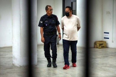 A soldier (right) was charged with allegedly kicking his five-year-old daughter at an eatery on Jalan Kuala Krai, Kota Bharu. -Bernama PIX