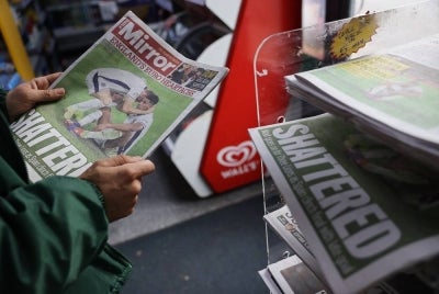 A person looks at a copy of the Daily Mirror as newspapers with frontage coverage of England's loss to Spain in the UEFA Euro 2024 final football match are sold at a shop in Lewes, southern England, on July 15, 2024. - (Photo by CARLOS JASSO / AFP)