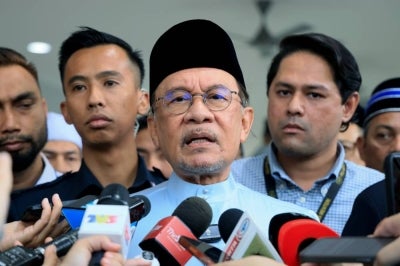 Prime Minister Datuk Seri Anwar Ibrahim speaking to reporters after performing Friday prayers at Surau Nur Perdana, today. - Photo by Bernama