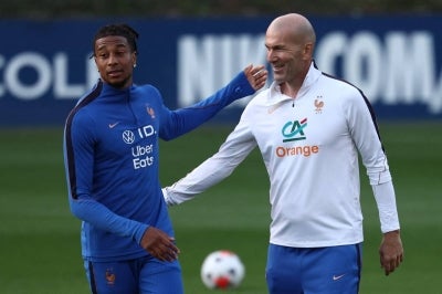 France's head coach Zinedine Zidane (R) greets France's forward Michael Olise (L). (Photo by FRANCK FIFE / AFP)