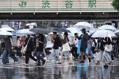 Pedestrians with umbrellas walk on a crossing as rain falls in Tokyo's Shibuya district on September 20, 2026. (Photo by Rie KIKUCHI / AFP)