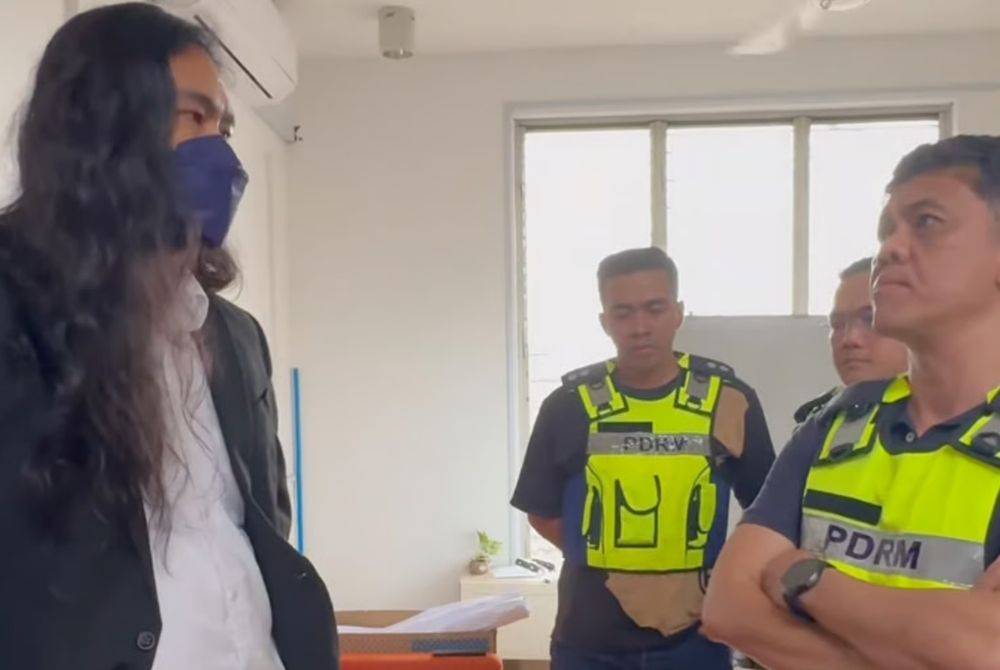 Lawyer Zaid Malek speaks to police officers who seized documents and records from the Mandiri and Hayat office on Sept 18. - Photo: Mandiri