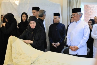 Sultan of Pahang, Al-Sultan Abdullah Ri'ayatuddin Al-Mustafa Billah Shah and Tengku Ampuan Pahang, Tunku Azizah Aminah Maimunah Iskandariah, pay their last respects to the late Tun Dr Hasmah Mohd Ali at Tun Dr Mahathir Mohamad's residence, yesterday. - Photo by Bernama