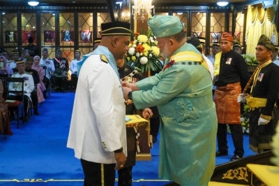 The Sultan of Kelantan, Sultan Muhammad V, confers the Ahli Yang Kehormat Yang Pertama (Seri Paduka) of the Order of the Crown of Kelantan (SJMK), which carries the title Datuk on Human Resources Minister Datuk Seri R. Ramanan during the investiture ceremony in conjunction with His Majesty's 57th birthday celebration at Istana Balai Besar today. - Photo by Bernama