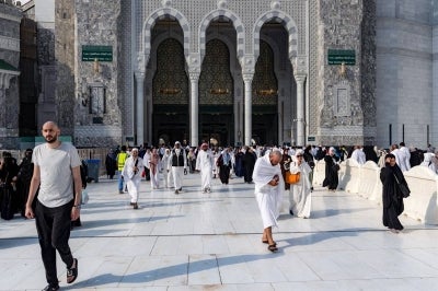 People and pilgrims walk at the Grand Mosque Complex in Saudi Arabia's holy city of Mecca on September 16, 2026. (Photo by AFP)