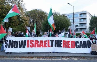 People hold placards calling on Ireland's football team not to play their next fixture against Israel, during a 'Stop The Game' protest outside Aviva Stadium in Dublin on October 1, 2026, ahead of the team's Nations League match against Austria. Ireland coach Heimir Hallgrimsson said on September 30 they will play their second Nations League match against Israel on October 4 after the first fixture was thrown into doubt by player concerns over the Gaza war. (Photo by Paul Faith / AFP)