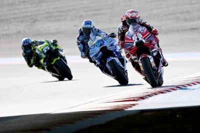 Marquez (middle) flew around the dry Motegi circuit in 1 minute 42.81 seconds(Photo by Toshifumi KITAMURA / AFP)