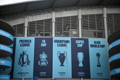Images of trophies won are pictured outside the Etihad Stadium, the home ground of Manchester City football club, in Manchester, north-west England on September 30, 2026. The Premier League said on September 29 that Manchester City have been found guilty of serious breaches of the Premier League's financial rules over a nine-season period between 2009 and 2018. (Photo by Oli SCARFF / AFP)