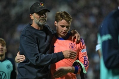 Germany's head coach Juergen Klopp (L) comforts Germany's goalkeeper #01 Jonas Urbig. (Photo by Aris MESSINIS / AFP)