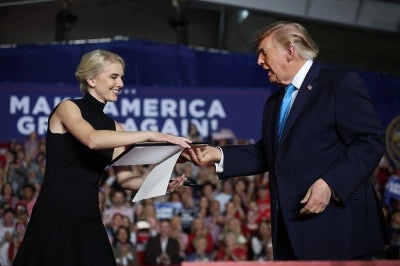 Presidential assistant Natalie Harp presents US President Donald Trump with an executive order to lower the cost of diesel fuel, which he signed during the rally at Pinnacle Bank Expo Center on the Nebraska State Fairgrounds on October 05, 2026 in Grand Island, Nebraska. Trump is campaigning for incumbent US Sen. Pete Ricketts (R-NE) and Gov. Jim Pillen ahead of the November midterm elections. -AFP Photo