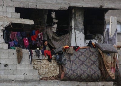 A Palestinian woman hangs laundry to dry inside a damaged building at the Jabalia refugee camp in the northern Gaza Strip on Oct 5. Photo by AFP