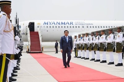 This handout photo taken and released by Myanmar's Presidential Press Information Bureau on October 7, 2026 shows Myanmar President Min Aung Hlaing walking past honour guards upon his arrival at Kuala Lumpur International Airport in Sepang. (Photo by Handout / Myanmar's Presidential Press and Information Bureau / AFP)