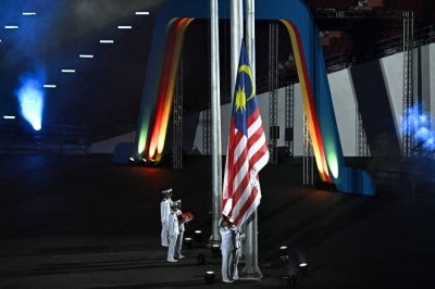Malaysia's national flag is raised during the handover of the Southeast Asian Games (SEA Games). (Photo by Lillian SUWANRUMPHA / AFP)