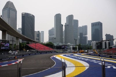 Air pollution is seen across the skyline as people prepare the street circuit before the Formula One Singapore Grand Prix night race in Singapore on October 8, 2026. (Photo by ANTHONY WALLACE / AFP)