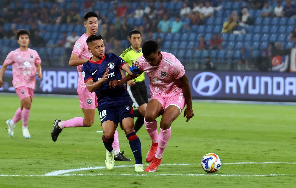 JDT player Arif Aiman Mohd Hanapi tries to get past PKR Svay Rieng FC player Mateus Barbosa Soares during the ASEAN Club Championship (ACC) Shopee Cup match at Sultan Ibrahim Stadium last night. Photo by Bernama