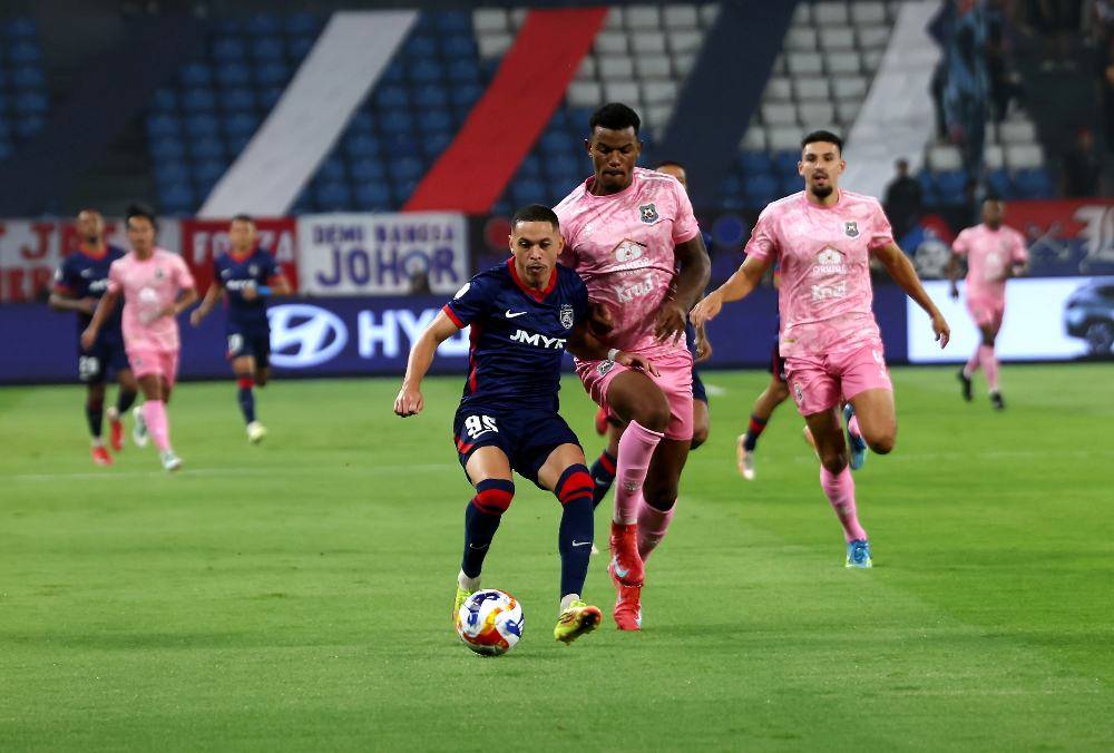JDT player Marcos Guilherme De Almeide Santos Matos is pressed by PKR Svay Rieng FC player Mateus Barbosa Soares during the ASEAN Club Championship (ACC) Shopee Cup match at Sultan Ibrahim Stadium last night. Photo by Bernama