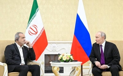 In this pool photograph distributed by the Russian state agency Sputnik, Russia's President Vladimir Putin and Iranian President Masoud Pezeshkian hold a meeting in Turkmenbashi on October 8, 2026. (Photo by Sergei BOBYLYOV / POOL / AFP)