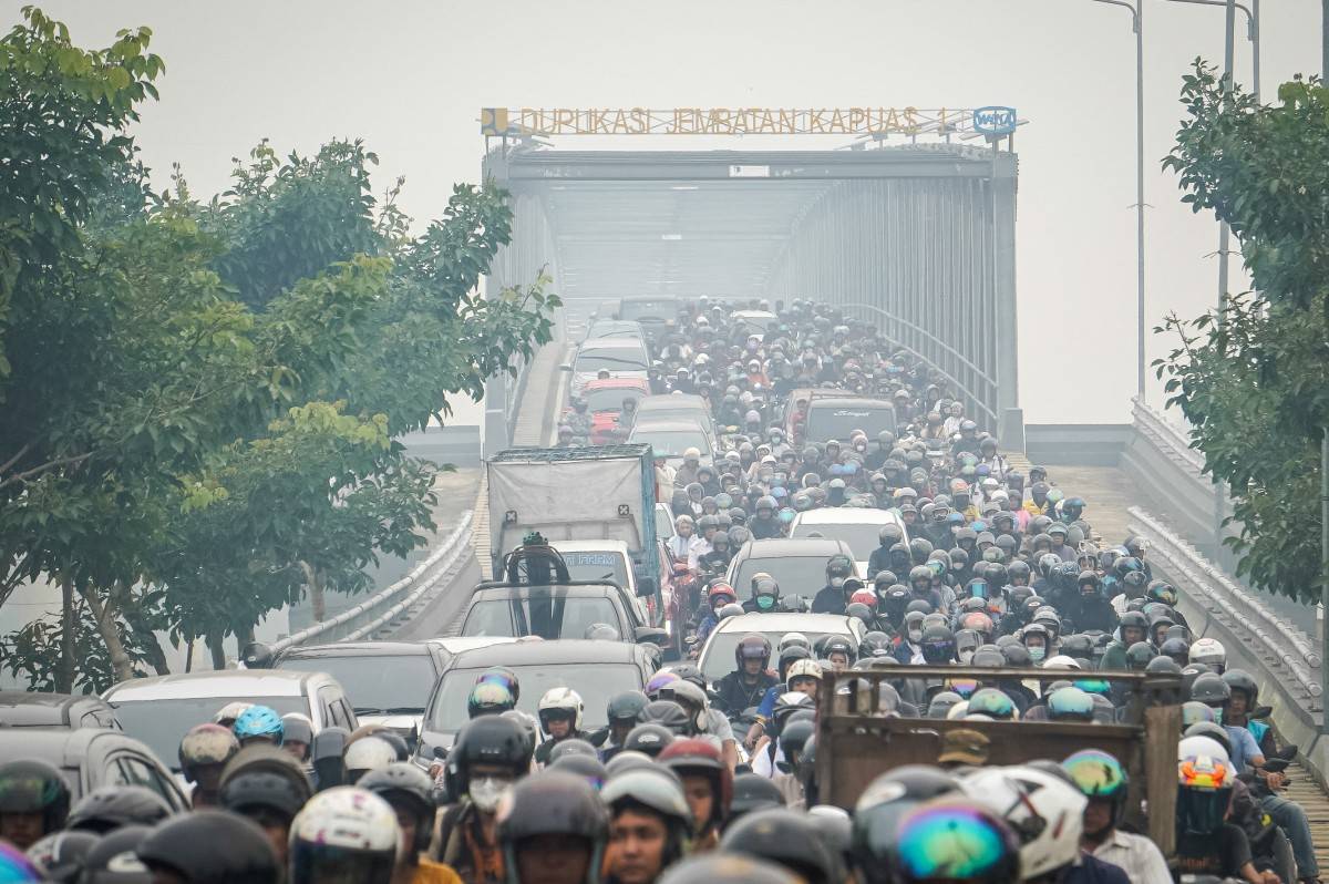 Motorists commute through thick haze caused by forest and land fires as they cross the Duplikasi Jembatan Kapuas 1 bridge in Pontianak, West Kalimantan. Photo by AFP