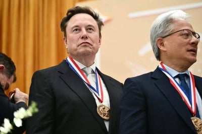 SpaceX CEO Elon Musk (L). (Photo by Kent NISHIMURA / AFP)