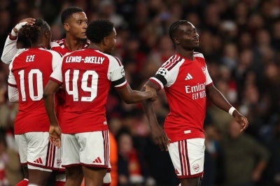Arsenal players celebrates their 3rd goal of the night. (Photo by Adrian Dennis / AFP)