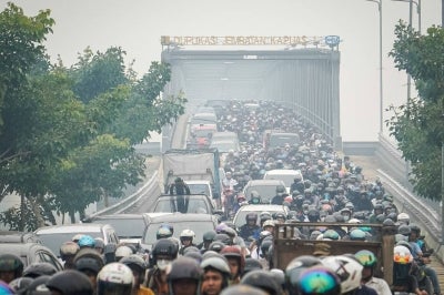 Motorists commute through thick haze caused by forest and land fires as they cross the Duplikasi Jembatan Kapuas 1 bridge in Pontianak, West Kalimantan. Photo by AFP