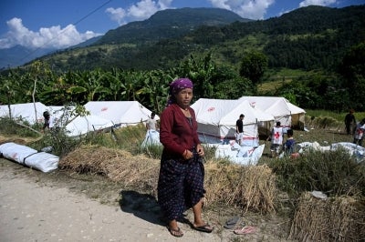 Flood victim Dal Kumari Thapa Magar looks on from near a temporary shelter at Shanti Bazar in Nepal. (Photo by Prakash MATHEMA / AFP)