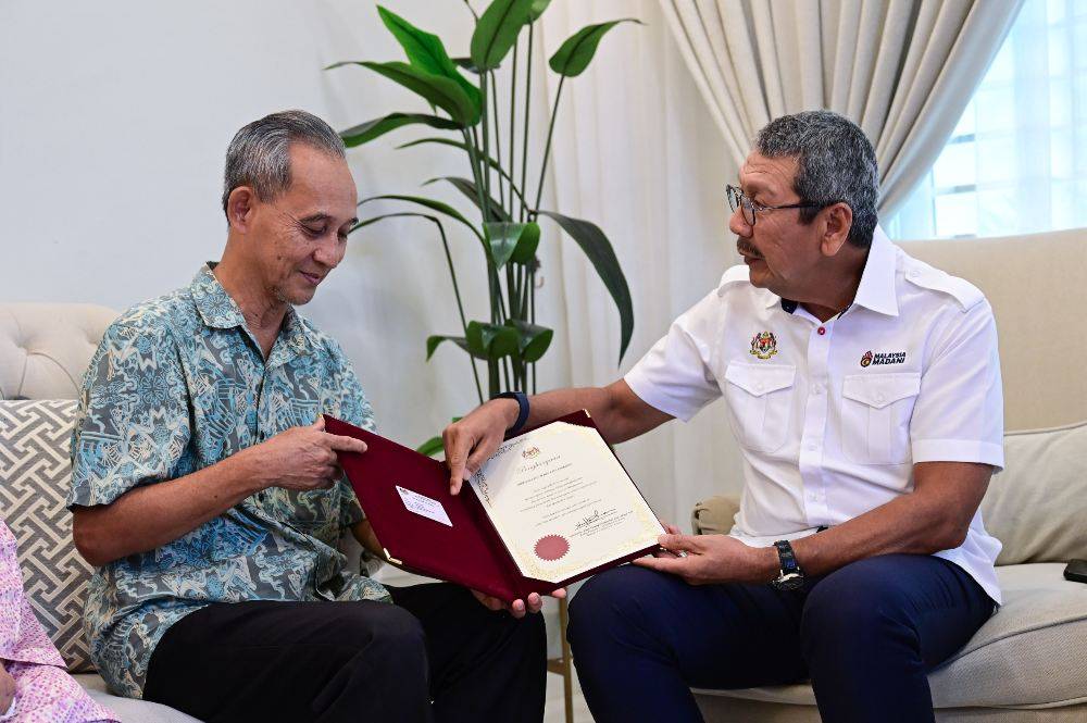 Tan Sri Dr Wan Ahmad Dahlan Abdul Aziz (right) during the 'Santuni Pesara' programme held around Kuala Terengganu and Kuala Nerus on Sunday. Photo by Bernama