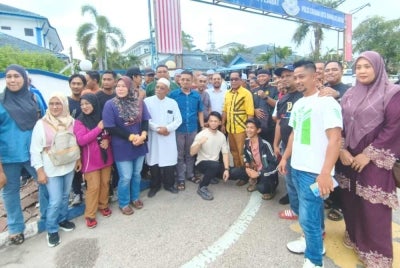 Abbe Hae (seventh from left) is greeted by his friends in front of IPD Kota Bharu after his release on Sunday.
