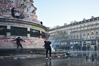 Protesters break up the fountain at the base of the 'Statue de La Republique' to get stones as clashes erupted at Place de la Republique following an unauthorised demonstration, central Paris, on October 18, 2026 a day after nationwide protests against the "high cost of living". France's Prime Minister Sebastien Lecornu said 1,200 people were arrested in protests across the country on October 17, and 150 police were hurt as clashes between police and protesters, massive looting and multiple blazes gripped France as nationwide marches against soaring inflation degenerated into street violence of "extreme intensity". (Photo by Matthieu RONDEL / AFP)