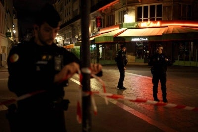 A police officer ties in place a perimeter tape near Chatelet - Les Halles to enforce a curfew, in central Paris on Oct 20. Photo by AFP