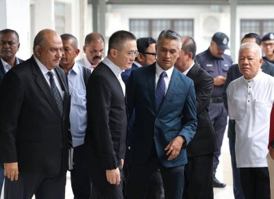 Malaysian Border Control and Protection Agency (AKPS) director-general Datuk Seri Mohd Shuhaily Mohd Zain (second right) arrives with his lawyer at the Sepang Court Complex today to face two charges over allegedly assaulting two policemen at Terminal 1 of Kuala Lumpur International Airport (KLIA). Photo by Bernama 