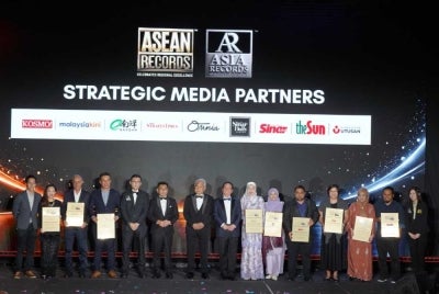Melaka Yang di-Pertua Negeri Tun Dr Mohd Ali Mohd Rustam (centre) poses for a group photograph with strategic media partners at the 10th Gather of Achievers, ASEAN Records and ASIA Records gala night at Hyatt Regency Kuala Lumpur on Tuesday. - Photo courtesy of ASEAN Records and ASIA Records
