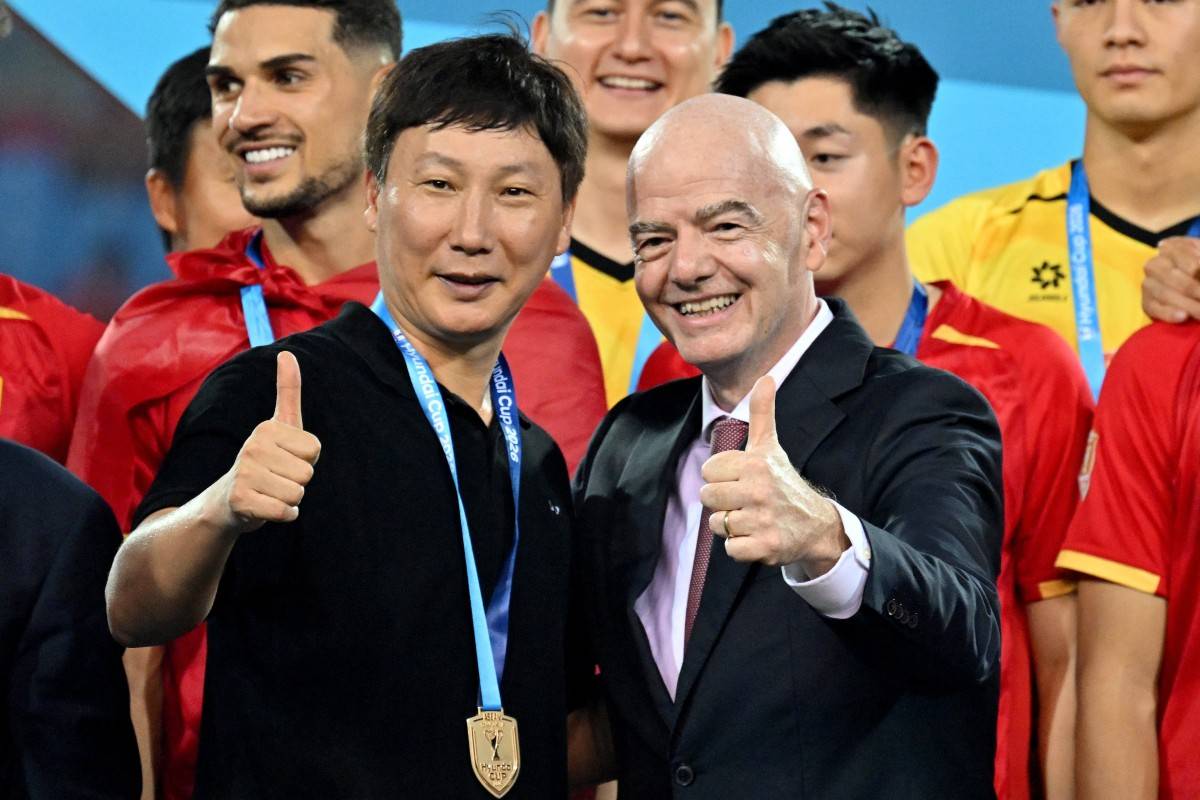 Vietnam's national team head coach Kim Sang Sik (L) and FIFA President Gianni Infantino (R) during the trophy presentation at the end of the ASEAN Championship Cup 2026 second leg final football match between Vietnam and Thailand in My Dinh National Stadium in Hanoi on August 26, 2026. (Photo by Nhac NGUYEN / AFP)