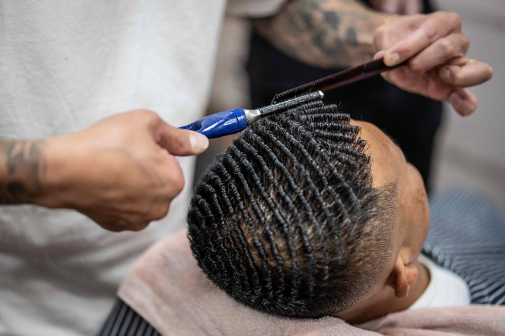 This photo taken on Aug 27, 2026 shows Tekisasu, an active yakuza gangster allied to a major clan, having his hair permed at a barbershop in Tokyo. - (Photo by YUICHI YAMAZAKI / AFP)