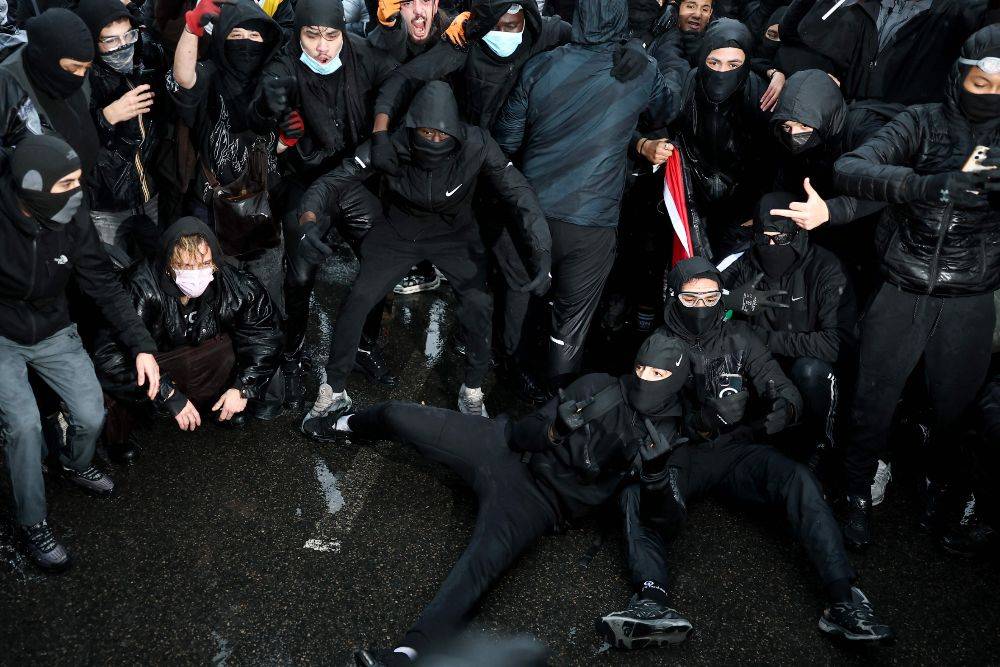 Protesters pose in front of photographers during a demonstration in favor of purchasing power, the protection of public services, and fiscal and social justice in Paris. Photo by AFP