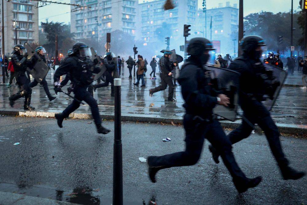 Police officers run as clashes erupted at the Porte de Vincennes on the sidelines of a demonstration in favor of purchasing power, the protection of public services, and fiscal and social justice. Photo by AFP
