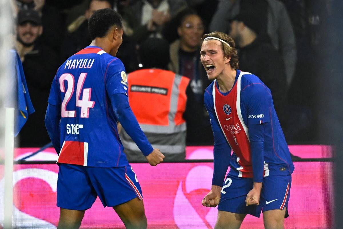 PSG's Belgian forward #22 Mika Godts (R) celebrates with PSG's French midfielder #24 Senny Mayulu (L) after scoring PSG's second goal during the French L1 football match between Paris Saint-Germain (PSG) and Olympique Lyonnais (OL) at the Parc des Princes stadium in Paris on October 26, 2026. (Photo by JULIEN DE ROSA / AFP)
