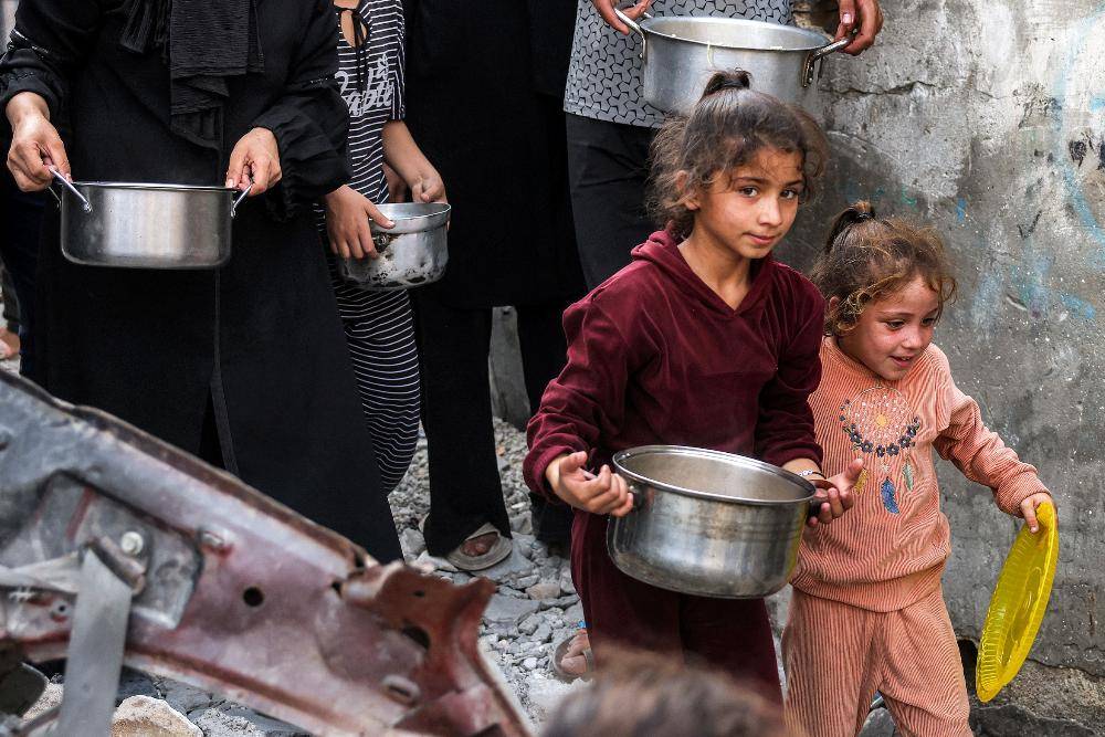 Children and others queue for meals at a charity kitchen in Jabalia refugee camp in northern Gaza, amid a food crisis that the Hind Rajab Foundation says was worsened by the destruction of a flour-producing facility. -AFP Photo