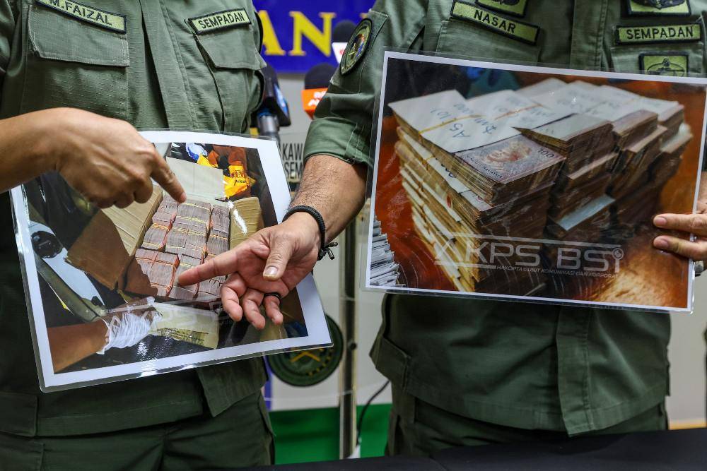 The Malaysian Border Control and Protection Agency (AKPS) detained a Malaysian couple suspected of attempting to take nearly RM3 million in undeclared cash out of the country at the Sultan Iskandar Building (BSI) Customs, Immigration and Quarantine Complex here yesterday. Photo by Bernama