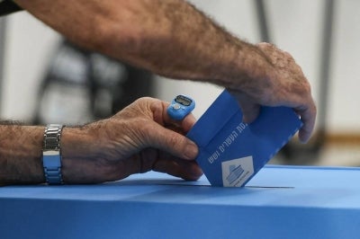 A man casts his ballot to vote at a polling station in the Arab-Israeli town of Umm al-Fahm on Oct 27, 2026, on the day of Israel's legislative election. - (Photo by AHMAD GHARABLI / AFP)