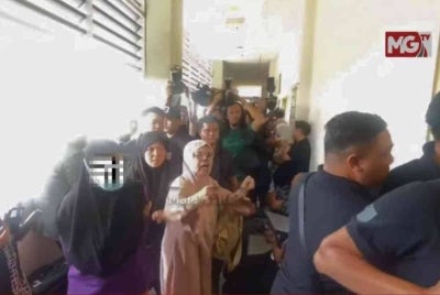 Ia diikuti ibu Zayn Rayyan yang turut memakai memakai pakaian lokap bewarna ungu. (Kredit foto: Tangkap layar MalaysiaGazette)