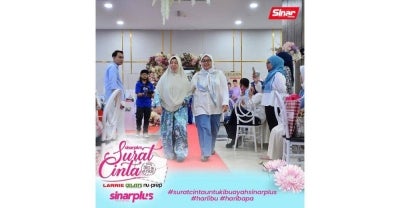 Ibu pemenang memperagakan baju yang indah tajaan dari Gulatis.