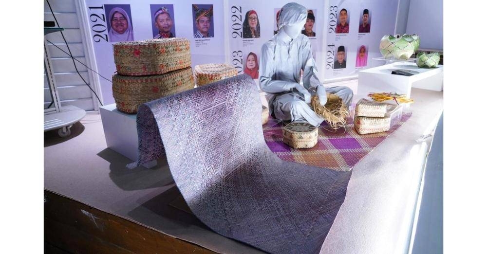 Mempamerkan pelbagai produk kraf anyaman yang dihasilkan oleh Adiguru Kraf.