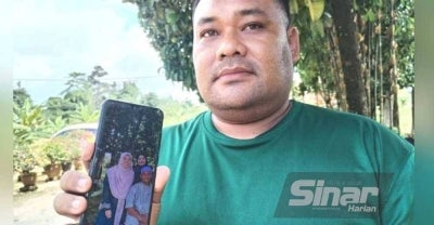 Mohd Farid Firdaus menunjukkan gambar arwah adiknya ketika ditemui pemberita di Kampung Gong Pasir Besut pada Isnin.
